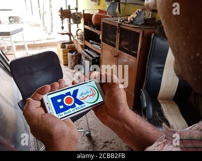 DISTRETTO KATNI, INDIA - 02 GIUGNO 2020: Un uomo indiano che detiene smartphone con la visualizzazione della banca del logo khyber sullo schermo, istruzione bancaria moderna c Foto Stock