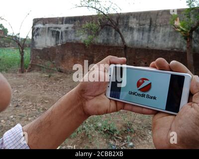 DISTRICT KATNI, INDIA - 02 GIUGNO 2020: Un uomo indiano che detiene smartphone con visualizzazione del logo della società di servizi finanziari UniCredit sullo schermo, moderno b Foto Stock