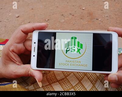 DISTRETTO KATNI, INDIA - 02 GIUGNO 2020: Una donna indiana in possesso di smartphone con visualizzazione del logo della Borsa del Pakistan sullo schermo, moderna banca islamica Foto Stock