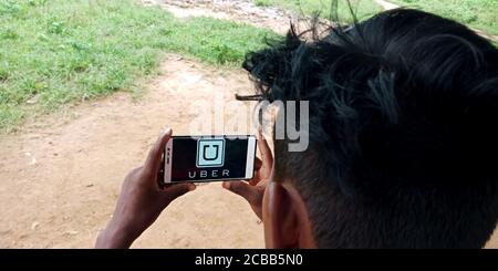 DISTRETTO KATNI, INDIA - 18 SETTEMBRE 2019: Uber Technologies Inc Ride sharing Company logo visualizzato sullo schermo dello smartphone da mano uomo villaggio indiano Foto Stock