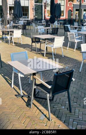 Terrazza vuota di un ristorante chiuso nei Paesi Bassi con molto spazio tra tavoli e sedie durante le restrizioni del coronavirus. Foto Stock