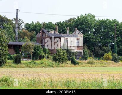 10 agosto 2020, Brandeburgo, Wustermark/OT Priort: Le rovine della stazione ferroviaria si trovano ai margini del villaggio accanto alla linea ferroviaria della circonvallazione esterna occidentale. L'edificio a due piani è stato costruito nel 1906. Al piano superiore c'erano due appartamenti per i dipendenti della ferrovia. Il piano inferiore era riservato al servizio con sala d'attesa, biglietteria, salotto e sala da lavoro per gli addetti alla stazione. La casa è stata bruciata nella notte del 23 settembre 2006 dopo Arson. Foto: Soeren Stache/dpa-Zentralbild/ZB Foto Stock