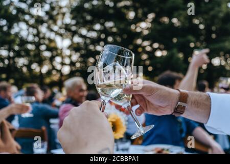 Primo piano di due persone che si acclamano con flauti di champagne Foto Stock