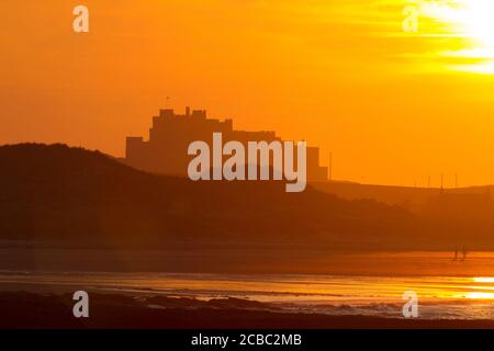 Tramonto sul Castello e sulla spiaggia di Bambburgh, Bamburgh, Northumberland, Regno Unito. Foto Stock