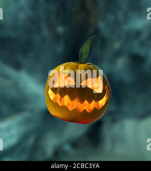 Zucca di Halloween con fiamma all'interno su sfondo offuscato astratto Foto Stock