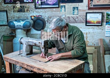 L'artista messicano Francisco Aguirre crea disegni in legno intarsiato utilizzando una macchina da cucire dotata di una lama fine presso il suo laboratorio di studio a Jalostoltitlan, Jalisco state, Messico. Aguirre è stato nominato un grande maestro dell'arte popolare messicana e i suoi oggetti fatti a mano sono raccolti in tutto il mondo. Foto Stock