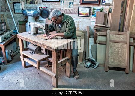 L'artista messicano Francisco Aguirre crea disegni in legno intarsiato utilizzando una macchina da cucire dotata di una lama fine presso il suo laboratorio di studio a Jalostoltitlan, Jalisco state, Messico. Aguirre è stato nominato un grande maestro dell'arte popolare messicana e i suoi oggetti fatti a mano sono raccolti in tutto il mondo. Foto Stock