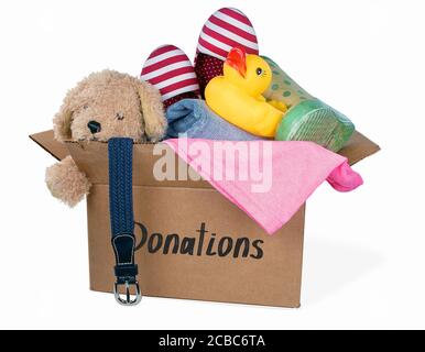 scatola di cartone riempita con giocattoli usati donati e vestiti isolati su bianco Foto Stock