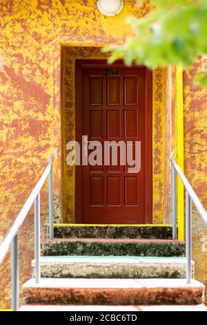 Scala che conduce ad una porta rossa Foto Stock