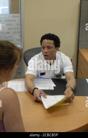 Georgetown, Texas USA, 5 agosto 2006: Grande evento di apertura pubblica per una filiale del centro bancario Capital One. Un rappresentante bancario lavora con un cliente che apre un nuovo conto. ©Bob Daemmrich Foto Stock