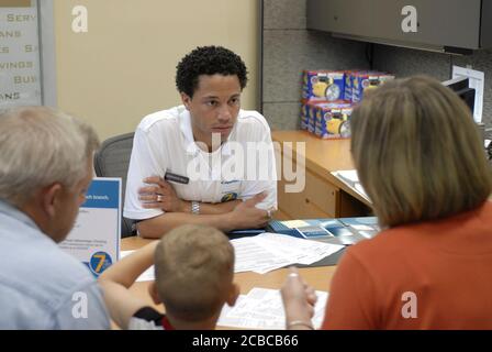 Georgetown, Texas USA, 5 agosto 2006: Grande evento di apertura pubblica per una filiale del centro bancario Capital One. Il rappresentante bancario lavora con i clienti che aprono un nuovo conto. ©Bob Daemmrich Foto Stock