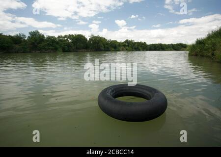 La Joya, Texas USA, 26 agosto 2007: Una camera d'aria usata da un contrabbandiere galleggia lungo un tratto remoto del Rio grande, il confine tra Messico e Stati Uniti, dove droga e persone attraversano regolarmente per evitare i posti di blocco della dogana statunitense. ©Bob Daemmrich Foto Stock