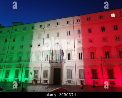 Roma, Italia - 12 agosto 2020: Emergenza Coronavirus in Italia, Palazzo Chigi, sede del governo italiano, illuminata con i colori della bandiera italiana Foto Stock