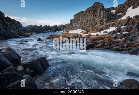 Acqua dalla cascata che spruzzi su un fiume roccioso Islanda Foto Stock