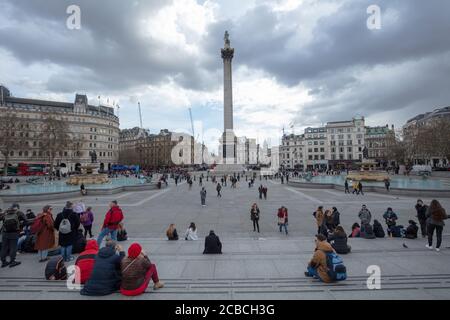 I turisti hanno visto in una vista generale di Trafalgar Square in una giornata nuvolosa ma asciutta in marzo. Foto Stock