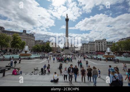 Turisti e piccioni visti sulla vista generale di Trafalgar Square dalla Terrazza Nord verso la colonna di Nelson in estate. Foto Stock