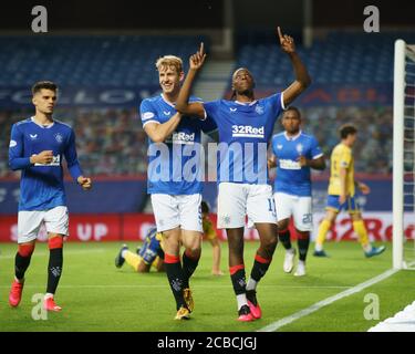 Joe Aribo of Rangers celebra, inseguito dal compagno di squadra Filip Helander, dopo aver segnato per dare loro un 3-0 di vantaggio durante la partita di premiership scozzese allo Ibrox Stadium di Glasgow. Foto Stock