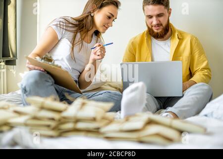 giovane coppia caucasica uomini d'affari con lettere a casa, che preparano lettere di ringraziamento per gli acquirenti dei loro prodotti. coppia sposata ha una f Foto Stock