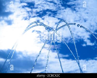 Fontana acqua fresca spruzzi su caldo sfondo cielo estivo. Acqua pulita o tema di rinfresco. Foto Stock