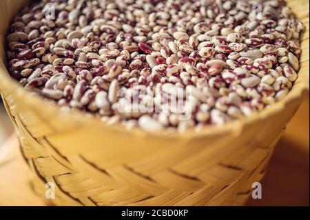 Esotici fagioli messicani colorati su cesto di vimini. Vista dall'alto dei legumi Foto Stock