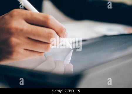 Primo piano uomo d'affari con penna stilo scrittura su tablet digitale. Web designer che lavora il suo progetto. Lavoro di affari in linea, tecnologia in linea. Foto Stock