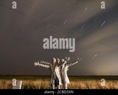 Leysdown, Kent, Regno Unito. 12 agosto 2020. UK Weather: Un cielo parzialmente nuvoloso per la vetta della Perseids meteora doccia a Leysdown, Kent. PIC: Percorsi stellari con la statua ai pionieri dell'aviazione Short Brothers. Credit: James Bell/Alamy Live News Foto Stock