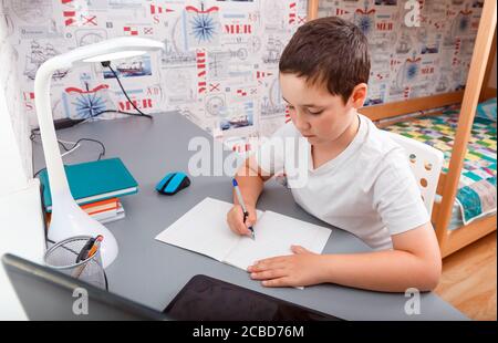 Scolaro che usa il computer desktop per studiare in linea homeschooling Foto Stock