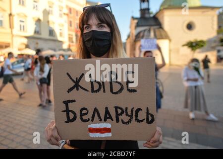 Cracovia, Polonia. 12 agosto 2020. Durante la manifestazione un manifestante tiene un cartello "Long Live Belarus".centinaia di persone bielorusse che vivono a Cracovia e sostenitori locali si sono riuniti per un raduno di solidarietà con le proteste bielorusse in corso, nella piazza del mercato di Cracovia, fuori dal monumento Adam Mickiewicz. Credit: SOPA Images Limited/Alamy Live News Foto Stock