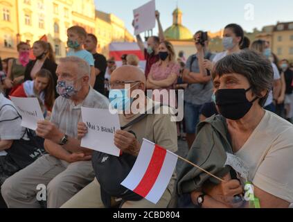 Cracovia, Polonia. 12 agosto 2020. Gli anziani ascoltano i discorsi durante la manifestazione.centinaia di persone bielorusse che vivono a Cracovia e i sostenitori locali si sono riuniti per un raduno di solidarietà con le proteste in corso bielorusse, nella piazza del mercato di Cracovia, fuori dal monumento Adam Mickiewicz. Credit: SOPA Images Limited/Alamy Live News Foto Stock