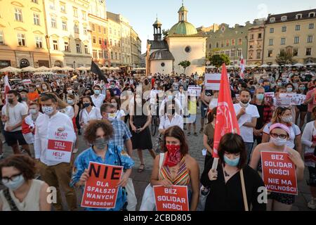 Cracovia, Polonia. 12 agosto 2020. I manifestanti ascoltano i discorsi durante la manifestazione.centinaia di persone bielorusse che vivono a Cracovia e i sostenitori locali si sono riuniti per un raduno di solidarietà con le proteste in corso bielorusso, nella piazza del mercato di Cracovia, fuori dal monumento Adam Mickiewicz. Credit: SOPA Images Limited/Alamy Live News Foto Stock