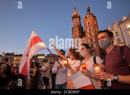 Cracovia, Polonia. 12 agosto 2020. I manifestanti hanno tenuto candele durante la dimostrazione.centinaia di persone bielorusse che vivono a Cracovia e i sostenitori locali si sono riuniti per un raduno di solidarietà con le proteste in corso bielorusso, nella piazza del mercato di Cracovia, fuori dal monumento Adam Mickiewicz. Credit: SOPA Images Limited/Alamy Live News Foto Stock