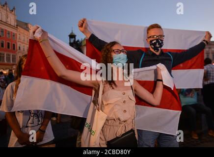 Cracovia, Polonia. 12 agosto 2020. Durante la manifestazione hanno tenuto bandiere bielorusse.centinaia di persone bielorusse che vivono a Cracovia e sostenitori locali si sono riuniti per un raduno di solidarietà con le proteste bielorusse in corso, nella piazza del mercato di Cracovia, fuori dal monumento Adam Mickiewicz. Credit: SOPA Images Limited/Alamy Live News Foto Stock