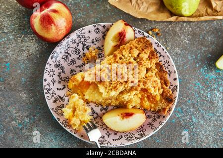 Una fetta di torta di pesche e pere su un piatto di cemento grigio-blu. Foto Stock
