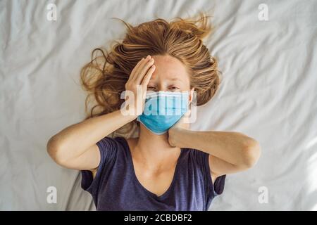 Donna giovane estremamente stanca sdraiata sul letto, a casa da sola. Autoisolamento a casa, quarantena a causa della pandemia COVID 19. Problemi di salute mentale in sé Foto Stock