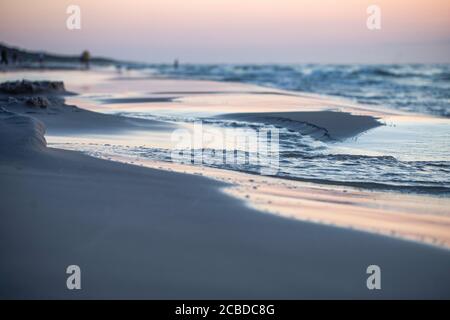 Spiaggia, tramonto sulle onde del Mar Baltico, Polonia, luce dell'ora d'oro. Foto Stock