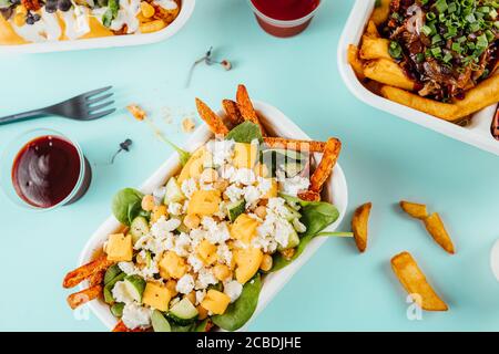 Vista dall'alto delle deliziose patate fritte con formaggio il contenitore Foto Stock