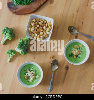 Purea di zuppa di crema verde fatta in casa con broccoli e crostini in ciotole su tavolo di legno. Cibo vegetariano sano Foto Stock