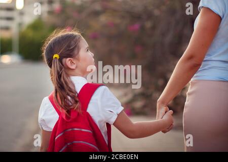 Ritorno a scuola. Concetto di cura dei genitori. Allievo e madre vanno a scuola. Foto Stock