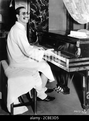 GROUCHO MARX sul set candid suonando piano in abito da notte Durante le riprese di ZUPPA D'ANATRA 1933 regista LEO McCarey storia Bert Kalmar e Harry Ruby Paramount Pictures Foto Stock