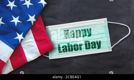 Happy Labor Day 2020, tempo del coronavirus. Festa nazionale americana, bandiera degli Stati Uniti, maschera di protezione cofid19 con testo su sfondo nero. Post festivo Foto Stock
