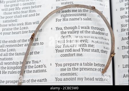 La Sacra Bibbia aprì nel Salmo 23 con un piccolo bastone sopra. Evidenziato sui versetti 3, 4 e 5. Primo piano. Shot orizzontale. Foto Stock
