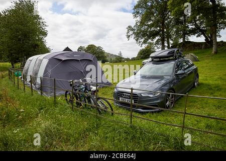 station wagon car con tenda grande in un campeggio campo con persone campeggio vicino loughrigg lake district cumbria inghilterra uk Foto Stock