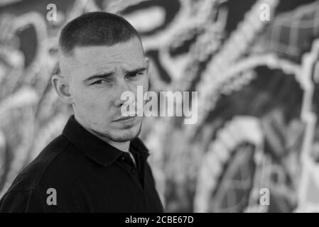 Ragazzo bully in camicia nera. Foto in bianco e nero. BW Foto Stock