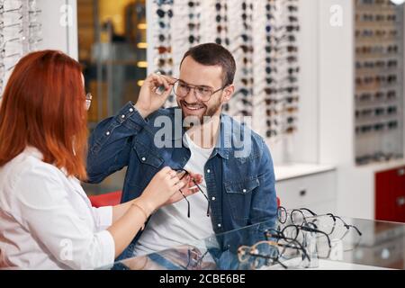 optahalmologist femminile che dà la raccomandazione ad un cliente, primo piano la foto Foto Stock