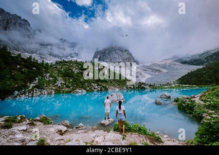 Coppia Visita il lago verde blu delle Dolomiti,splendido lago Sorapis Lago di Sorapis nelle Dolomiti, meta turistica molto apprezzata in Italia Foto Stock