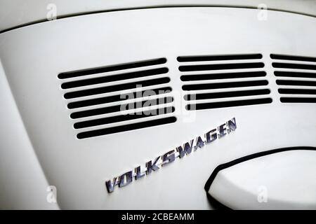 Dettaglio di un vecchio classico Volkswagen VW Beetle, in primo piano logo VW e perforazioni del cofano Foto Stock