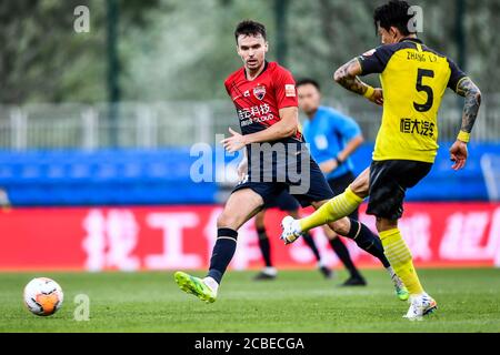 Il calciatore norvegese Ole Selnaes di Shenzhen F.C., a sinistra, protegge la palla durante la terza partita della Super League Cinese 2020 (CSL) contro Guangzhou Evergrande Taobao nella città di Dalian, provincia di Liaoning della Cina nordorientale, il 4 agosto 2020. Guangzhou Evergrande Taobao batte Shenzhen F.C. con 3-1. Foto Stock