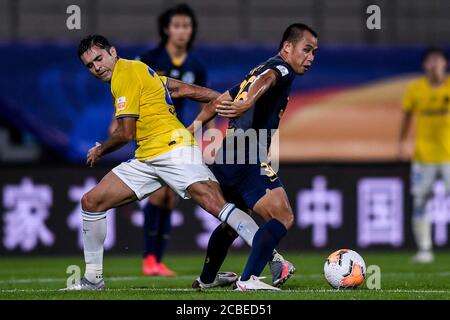Il calciatore italo-brasiliano Eder Citadin Martins, conosciuto semplicemente come Eder, del Jiangsu Suning F.C., a sinistra, lotta per la palla durante la quarta partita di 2020 Chinese Super League (CSL) contro Guangzhou R&F F.C., città di Dalian, provincia di Liaoning della Cina nordorientale, 9 agosto 2020. Guangzhou R&F F.C. è stato sconfitto da Jiangsu Suning F.C. con 0-2. Foto Stock
