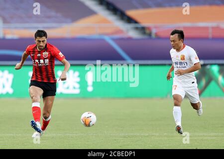 Il calciatore uzbeko Odil Ahmedov di Shanghai SIGG F.C., a sinistra, tiene la palla durante la quarta partita della Super League Cinese 2020 (CSL) contro Wuhan Zall F.C., Suzhou città, provincia di Jiangsu della Cina orientale, 12 agosto 2020. Shanghai SIPG F.C. sconfisse Wuhan Zall F.C. con 2-1. Foto Stock