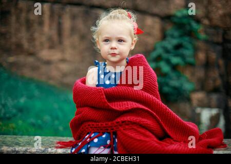 ragazza avvolta in una coperta di lana rossa Foto Stock